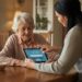 Veilig data delen met uw mantelzorger: Senior deelt veilig data met mantelzorger en geeft toestemming op tablet in huiselijke setting