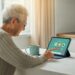 Oudere vrouw gebruikt een tablet in een warme huiskamer, met focus op digitale vaardigheden voor ouderen