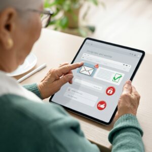 Oudere vrouw bedient een tablet in een rustige, moderne setting met focus op gebruiksgemak en online veiligheid voor senioren