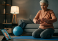 Een oudere persoon die thuis een fysiotherapieoefening doet met een tablet, begeleid door digitale fysiotherapie thuis voor ouderen.